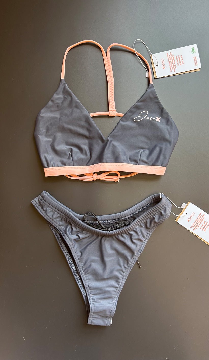 The Arya Bikini Top by Jaze shown from the front comes with thin, pink stripes and is combined with our midnight bikini bottom.