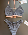The Arya Bikini Top by Jaze shown from the front comes with thin, pink stripes and is combined with our midnight bikini bottom.