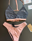 The Arya Bikini Top by Jaze shown from the front comes with thin, pink stripes and is combined with our sunrise bikini bottom.