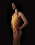 Side profile of a woman in the Amy one piece swimsuit by Jaze Swimwear, highlighting the high cut leg, secure adjustable straps and elegant sporty design for pro swimmers.