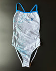 FLOWER OF LIFE - One-Piece Swimsuit lying on a black surface showing the high cut leg and the blue straps.
