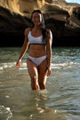 Our Model shown from the front wearing our Flower of life – Bikini bottom with a white base and light blue patterns.