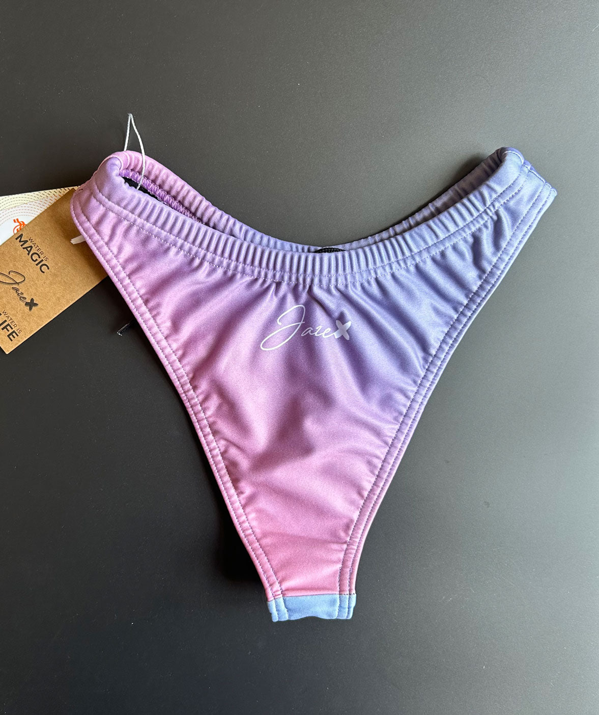 The RAINBOW - Bikini Bottom shown from the back clying on a black surface for more details.