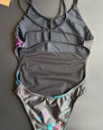 Back view of the Universe Swim Onesie on a black background, featuring the open-back cut and elegant fit.
