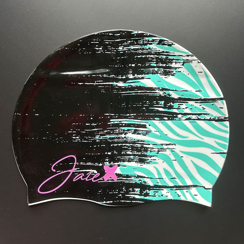The ZEBRA - swim cap turns from midnight black in the front to a zebra style pattern in the color turquoise at the back.