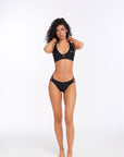 Model wearing black Alana bikini bottom in front pose with clean minimal design