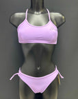 Jaze Ariel bikini bottom in lavender on a mannequin, front view showing adjustable side straps and sleek performance design.
