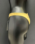 Side view of honey yellow bikini bottom by Jaze on mannequin, highlighting premium durable material, sleek sporty fit and vibrant color.