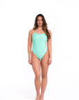 Model wearing jade one piece swimsuit in studio front pose with natural stance