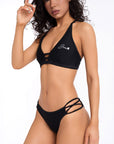 Woman wearing black Lilly bikini top and Alana bikini bottom with strappy detail and supportive fit