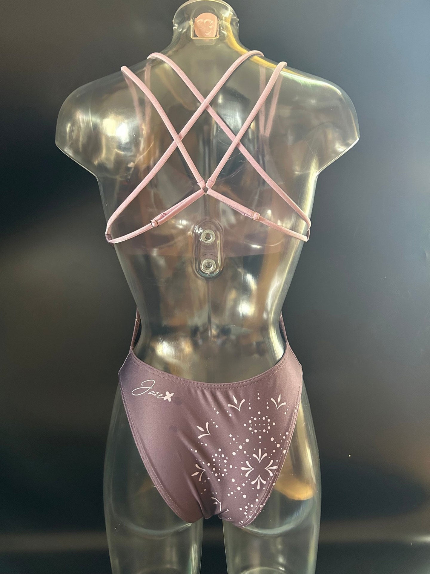 The Lila "Moonlight" one-piece swimsuit shown from the back on a mannequin, showing the open back and the adjustable straps.