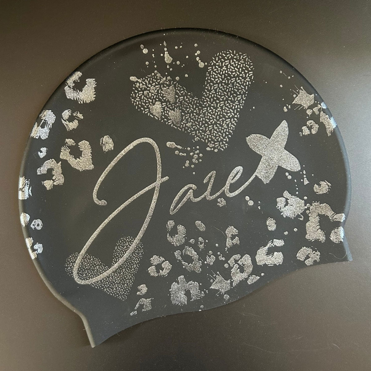 Swim Cap - Onyx with stylish silver glitter print lying on a black surface for more details.