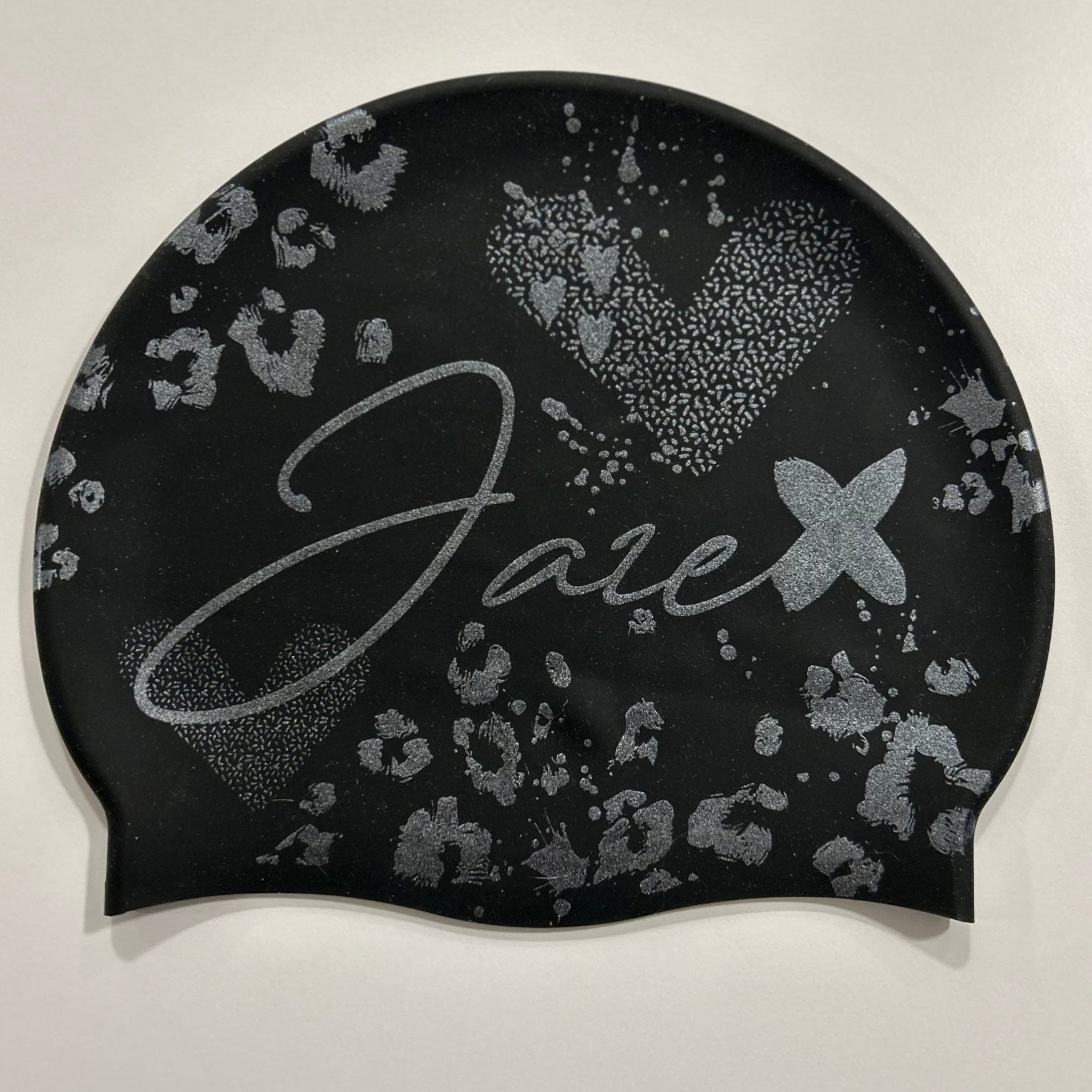 Swim Cap - Onyx with stylish silver glitter print lying on a black surface.