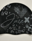 Swim Cap - Onyx with stylish silver glitter print lying on a black surface.