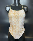 Lana one piece swimsuit on a mannequin in the color gold and white shown from the front with a black background.