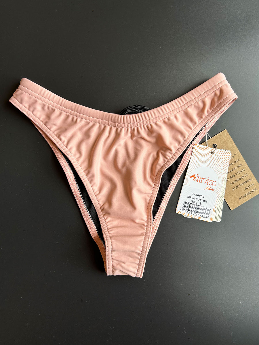 The peach Sunrise – Bikini bottom shown from the back comes with a high leg cut and is showing a bit more from your butt ckeeks than regular buttoms in a very athletic way.