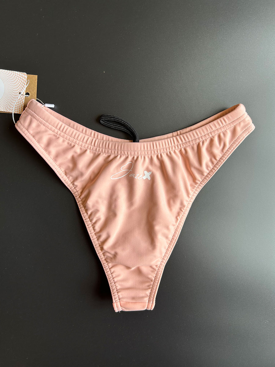 The peach Sunrise – Bikini bottom shown from the front comes with a high leg cut.