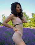 Side view of a female model in the Sunrise Bikini Top, standing in a lavender field, highlighting the bikini's sleek side profile.