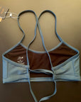 Ariel Bikini Top shown from the back lying on a black background, showing the adjustable straps for perfect support.