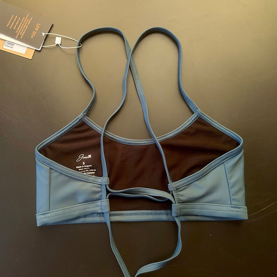 Ariel Bikini Top shown from the back lying on a black background, showing the adjustable straps for perfect support.