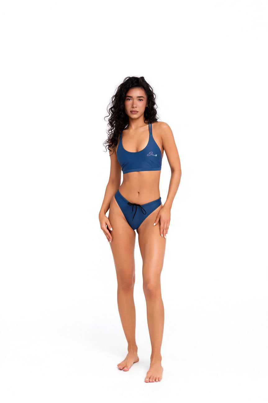 Front view of blue Sea bikini top in minimal studio setting